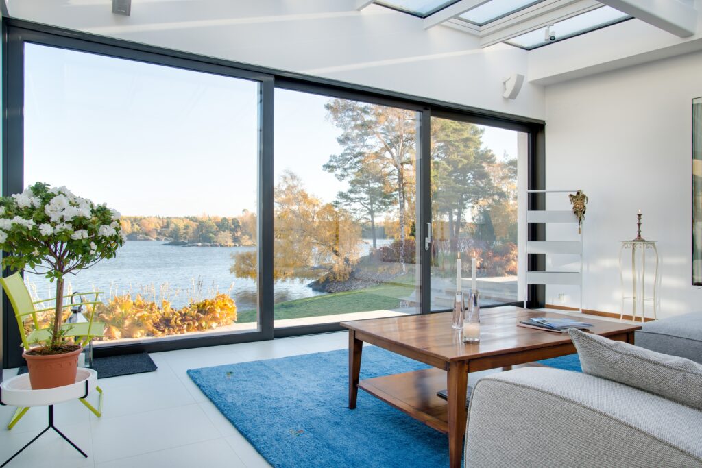 Baie vitrée à galandage d'une maison avec vue sur lac.